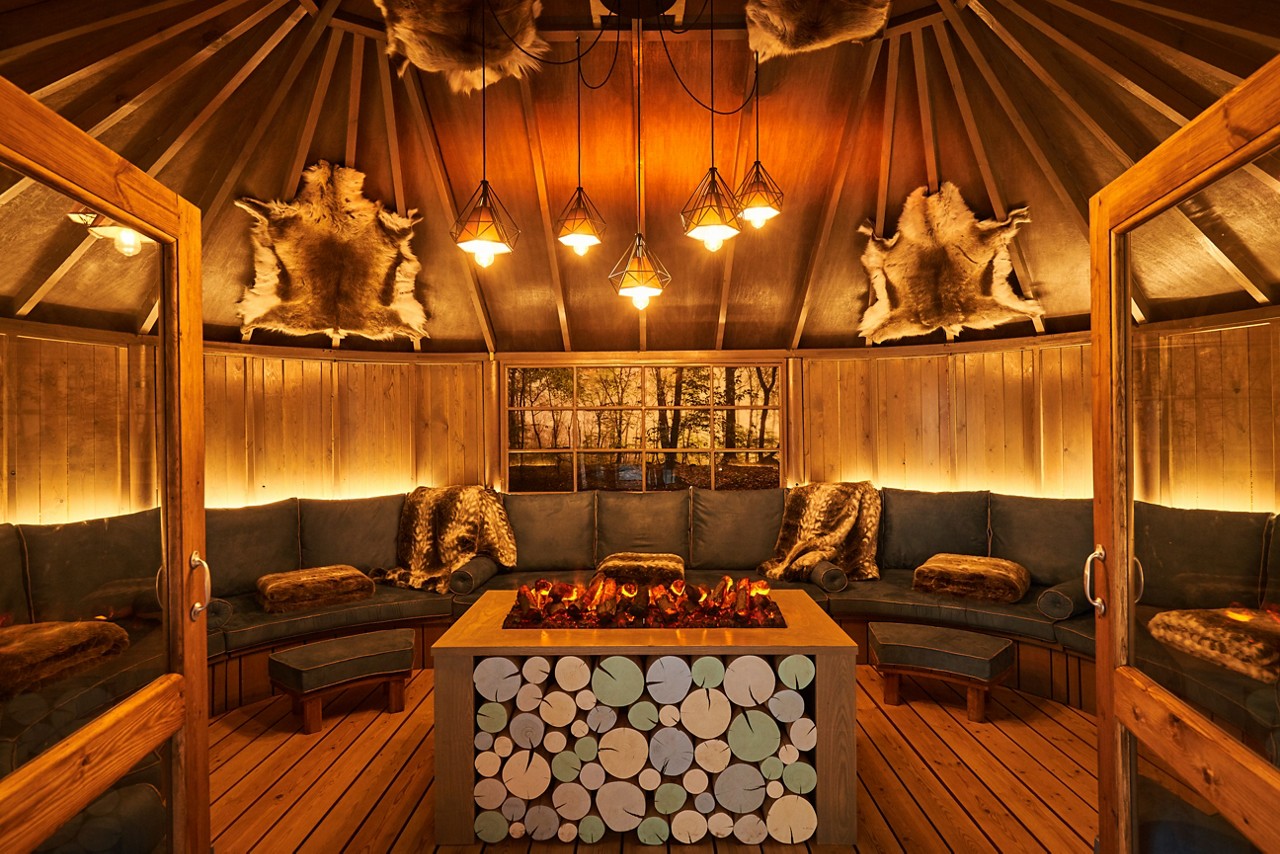 Scandinavian Snug with a central glowing fire and cosy seating.